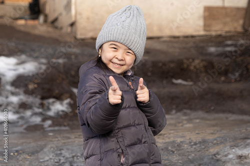 child shows thumbs up and smiles