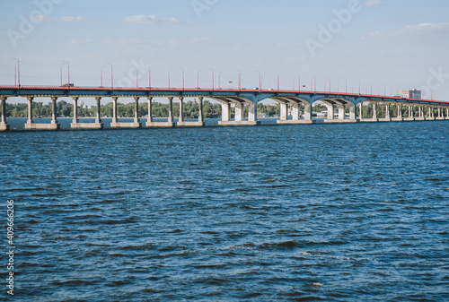 A large, high biton bridge stands on the blue Dnieper River. 