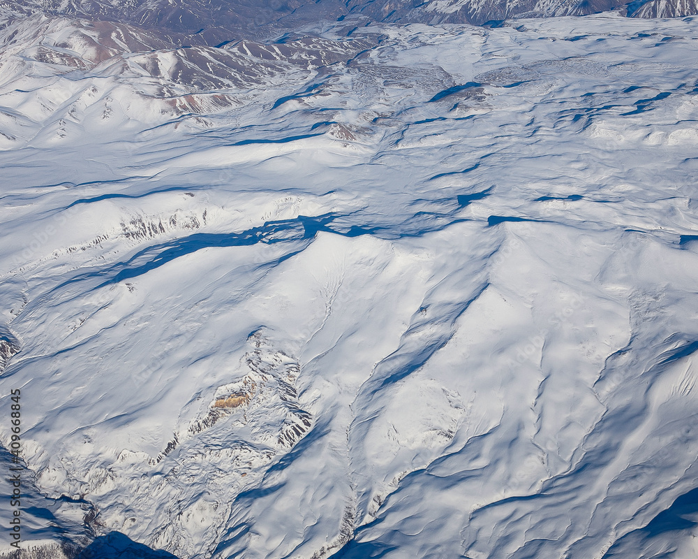 Fototapeta premium Flight over the Caucasus mountains by plane.