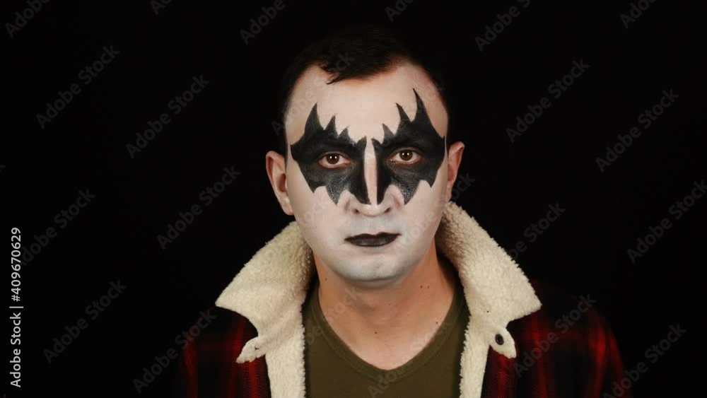 Man in demon makeup posing to camera on black background Man in demon makeup posing to camera on black background