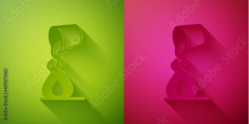 Paper cut Water bucket extinguishing a fire icon isolated on green and pink background. Paper art style. Vector.