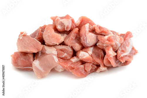 Raw pork meat cut into pieces, isolated on a white background.