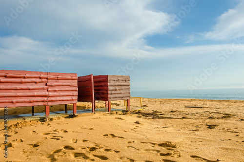 Cabana for changing clothes on the beach near the sea.Wooden changing room on the beach. © Сергей Лаврищев