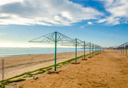 Empty frames of canopies without awnings on a winter beach.Umbrellas for shade on an empty beach.