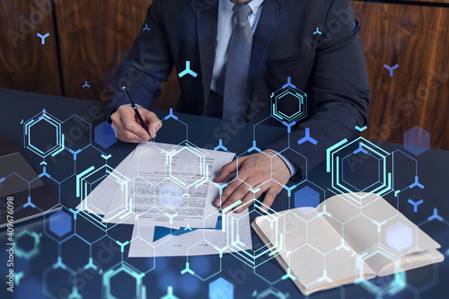 A client in dark blue suit is signing a contract to create a new software to present it in start up conference and gain investments to create a product. Technological graph over the desk.