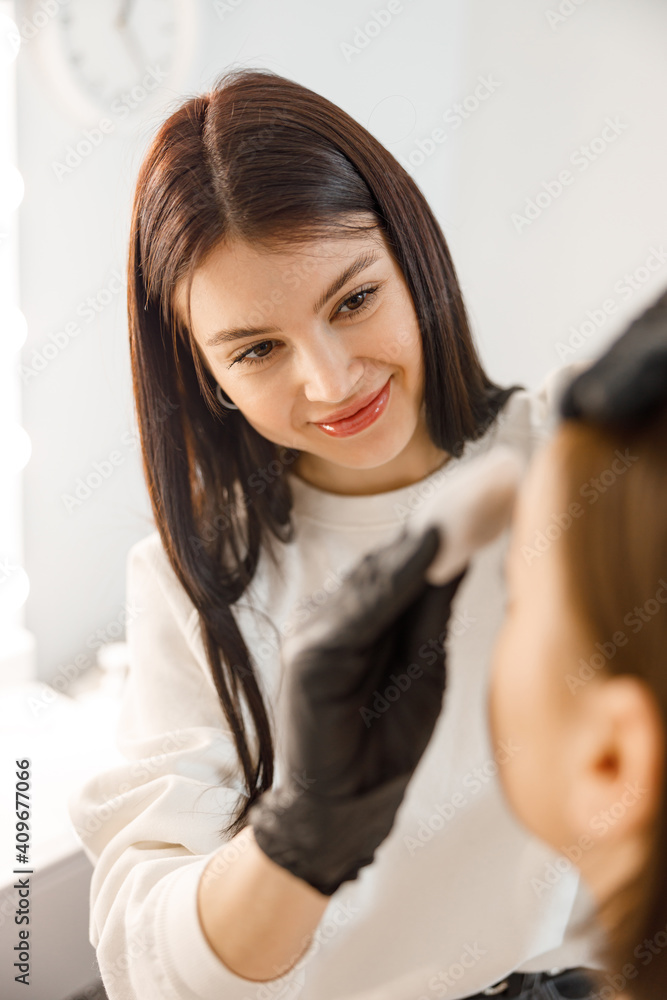 Professional brow master is doing her job for beautiful caucasian woman at beauty salon Professional brow master is doing her job for beautiful caucasian woman at beauty salon