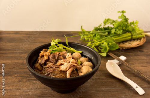 Hot and Spicy Nam Tok noodles soup with meat balls.Thai boat noodles is Street food of Thailand style, that famous noodles soup,Thai Boat noodles soup or Guay tiew reua, Rice noodles thicken soup. photo