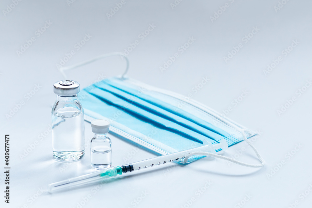 Vaccine vial, syringe and mask on white background Vaccine vial, syringe and mask on white background
