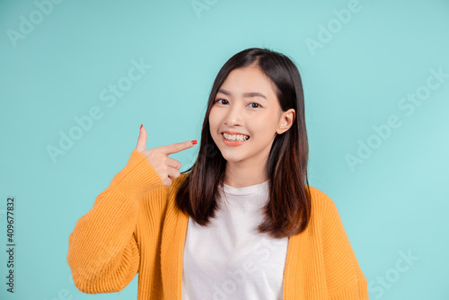 Schilderij op canvas Dental of young asian woman wearing retainer braces glad emotion with white teeth increase confidence for healthy on blue background isolated, Happiness teenager smiling facial expression