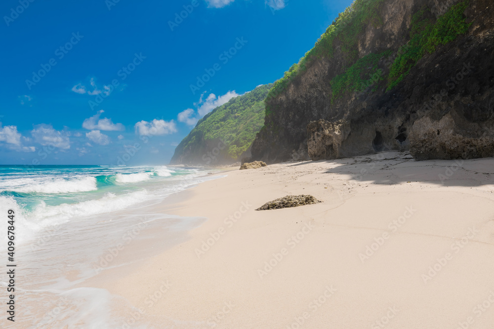 Tropical beach at paradise island. Sandy beach and blue ocean with wave Tropical beach at paradise island. Sandy beach and blue ocean with wave