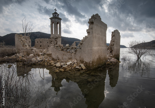 Ruins of an abandoned and deserted church in the water of a dam. photo