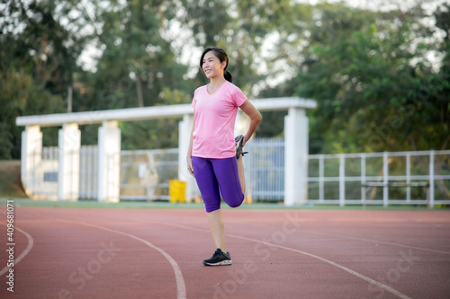 Asian girl is stretching her body warm muscles before going out for a run at the park © Worranan