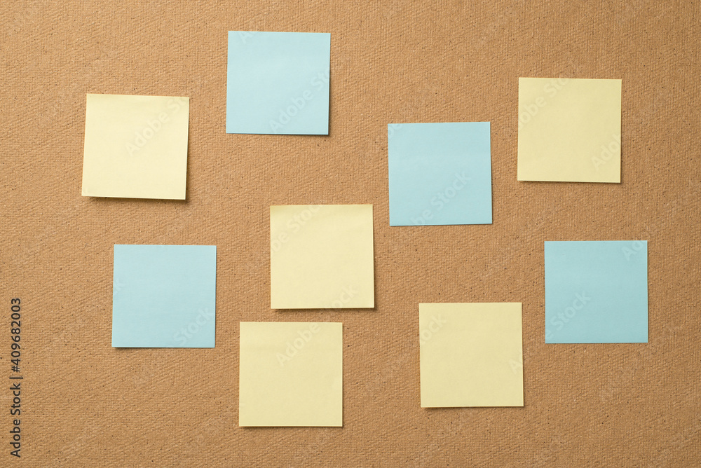 Photo of empty light color yellow and blue stickers attached to the wooden board Photo of empty light color yellow and blue stickers attached to the wooden board