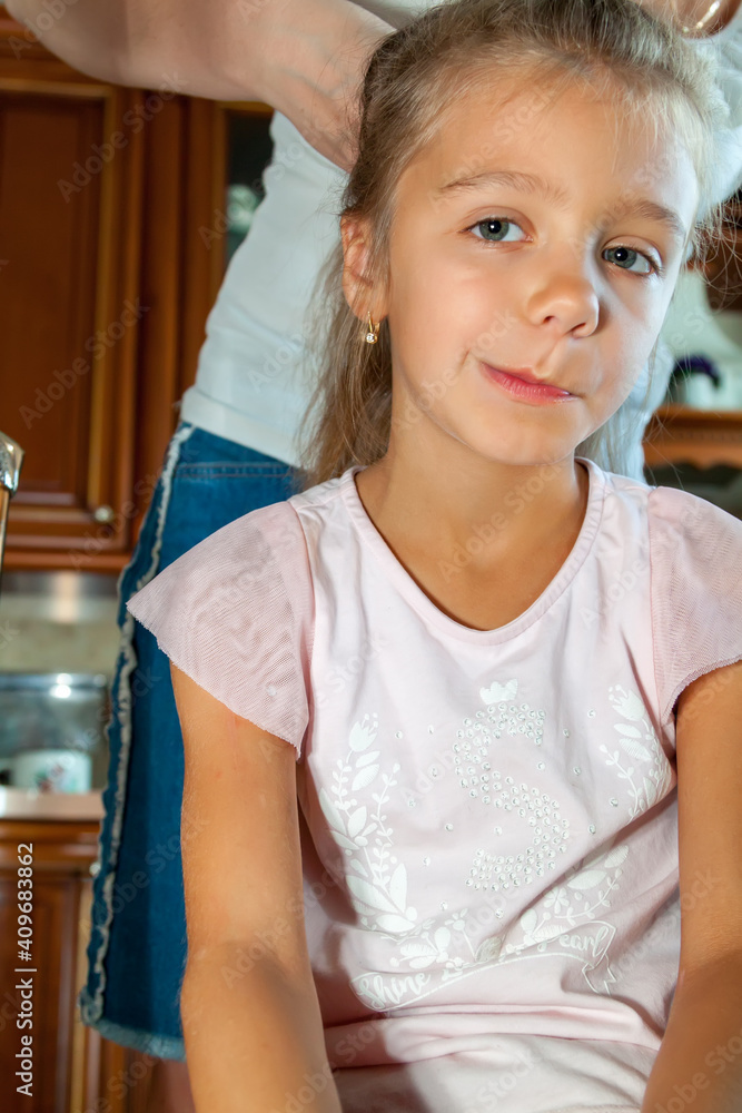 Mother combs her daughter hair and braids it at home Mother combs her daughter hair and braids it at home