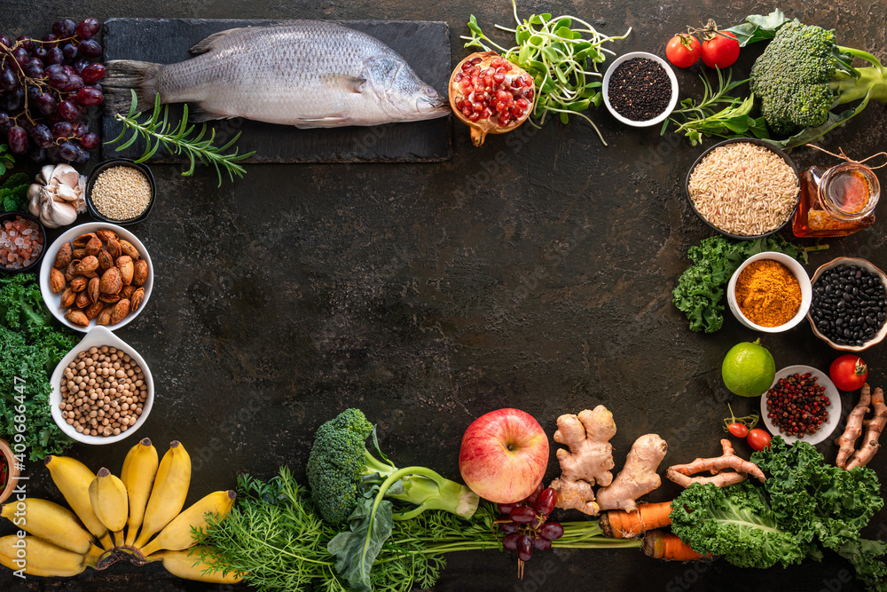 Healthy food clean eating selection: fish,fruit, vegetable, seeds, superfood, cereals, leaf vegetable on old kitchen table background copy space. Healthy food for humans. Background with for text Healthy food clean eating selection: fish,fruit, vegetable, seeds, superfood, cereals, leaf vegetable on old kitchen table background copy space. Healthy food for humans. Background with for text