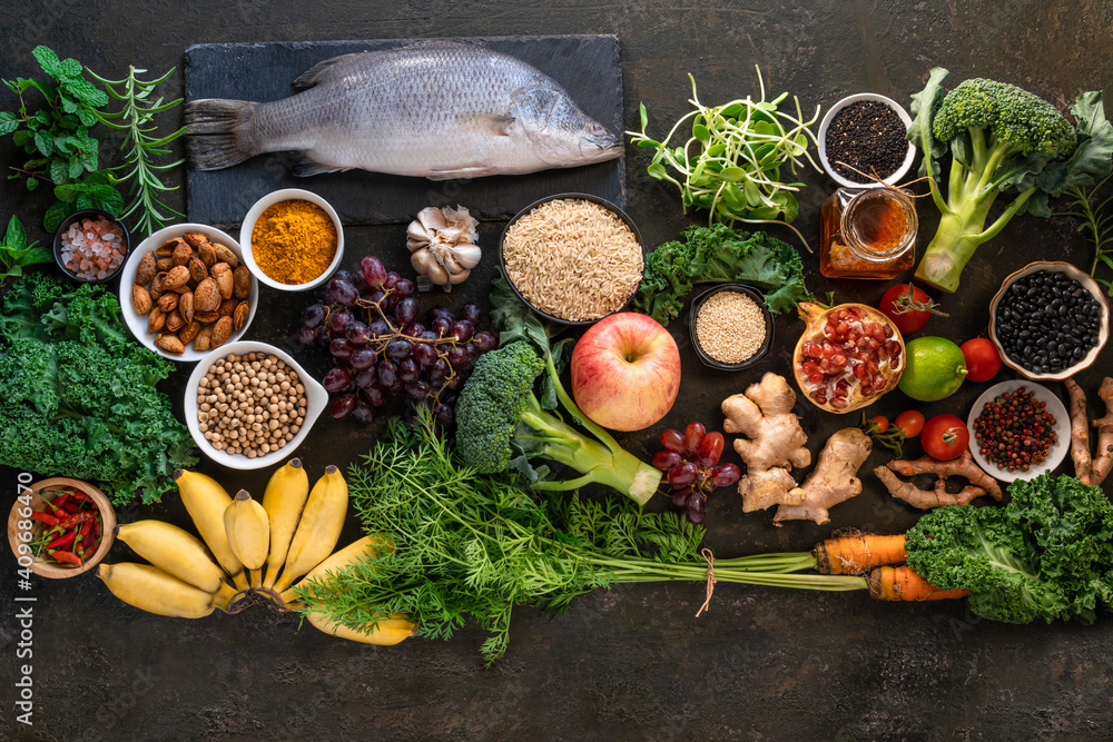 Healthy food clean eating selection: fish,fruit, vegetable, seeds, superfood, cereals, leaf vegetable on old kitchen table background copy space. Healthy food for humans Healthy food clean eating selection: fish,fruit, vegetable, seeds, superfood, cereals, leaf vegetable on old kitchen table background copy space. Healthy food for humans