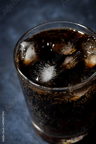 glass of coca cola with ice on a dark background, top view vertical