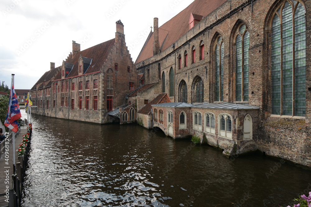 Bruges, Belgium. View of beautiful church and historical building and waterfront from the canal