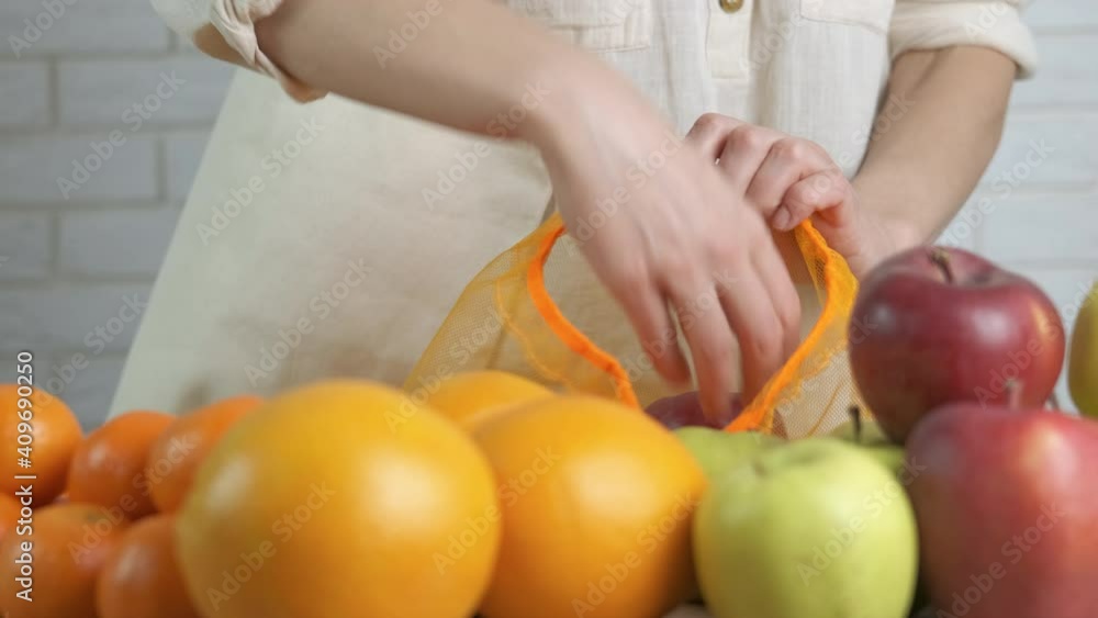 Woman with an eco bag. A woman puts fruits in a reusable bag. Woman with an eco bag. A woman puts fruits in a reusable bag.