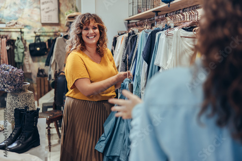 Clothing store owner assisting customer in her store photo