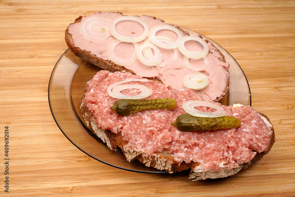 2 Belegte Brote mit Hackepeter, Zwiebelmett, Leberwurst auf Glasteller 2 Belegte Brote mit Hackepeter, Zwiebelmett, Leberwurst auf Glasteller