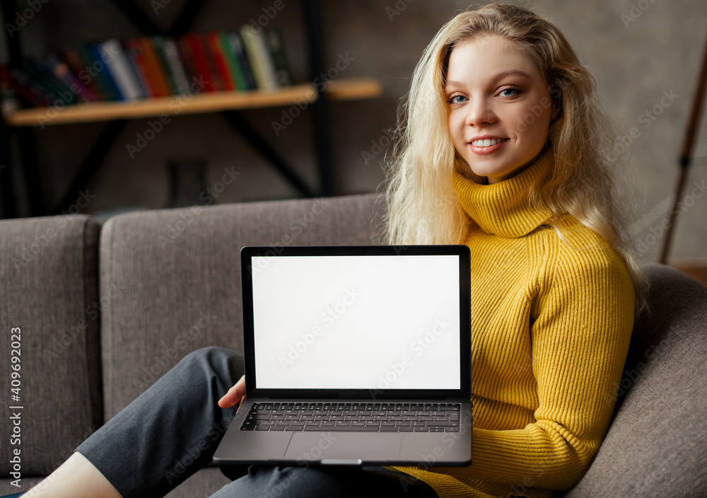 student girl sit on sofa holding laptop looking at mock up screen, online learning on pc, e learning. Closeup view student girl sit on sofa holding laptop looking at mock up screen, online learning on pc, e learning. Closeup view