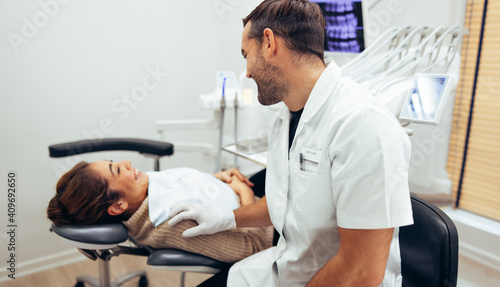 Dentist talking with female patient