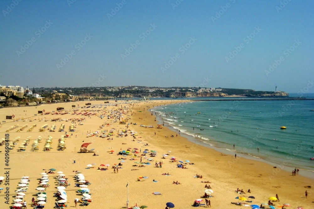 View from the cliffs to people on the beach Praia da Rocha at Portimao. Algarve beach during the summer vacation, Portugal, Europe.