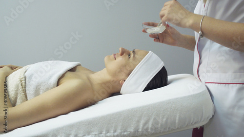 Woman having mask applied during spa facial treatment