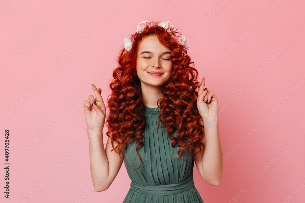 Portrait of charming lady in khaki dress smiling and crossing her fingers. Girl with red curly hair smiles with closed eyes Portrait of charming lady in khaki dress smiling and crossing her fingers. Girl with red curly hair smiles with closed eyes
