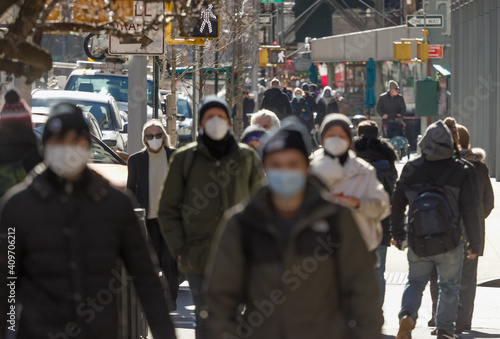 Crowd of people walking street wearing masks during covid 19 coronavirus pandemic