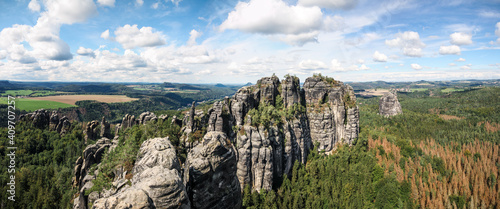 wide panorama of schrammsteine rock-formation in saxon switzerland, elbe sandstone highlands, germany with blue sky
