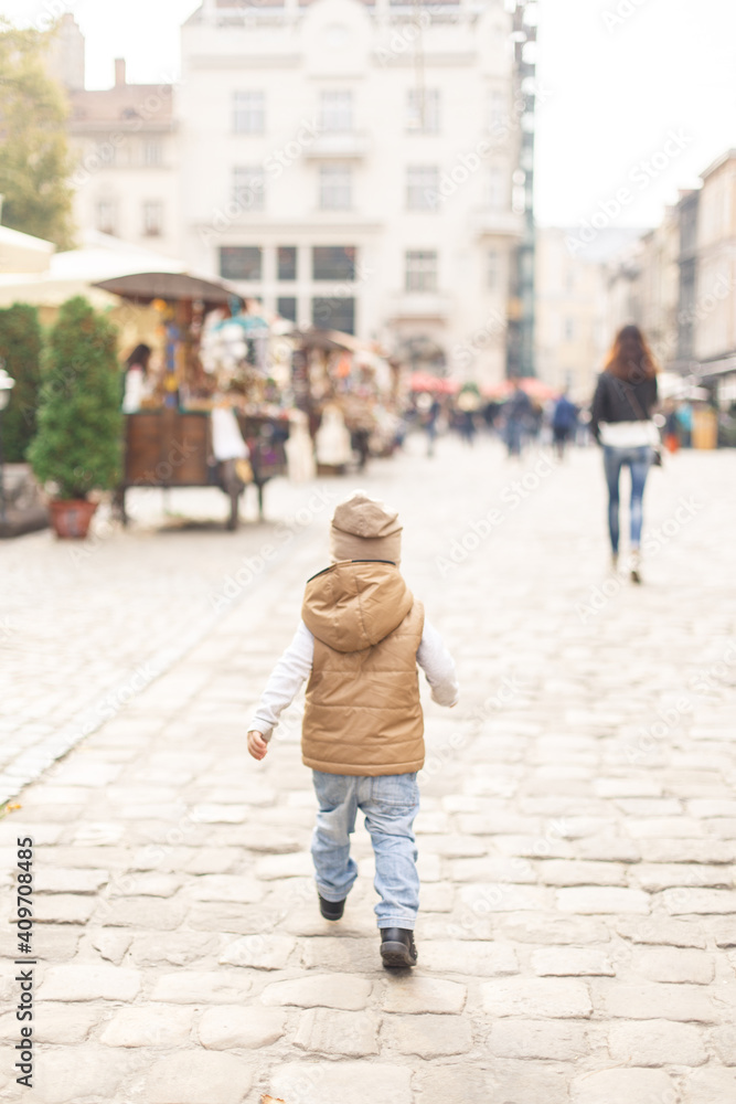 a little boy walking alone in the old town