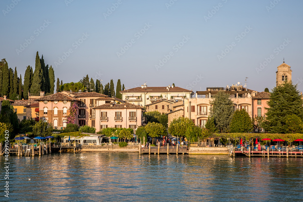 The pier and promenade of Sirmione on Lake Garda. Autumn evening. Lombardy, Italy