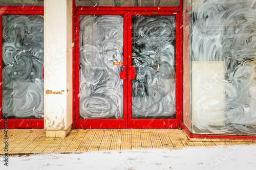 Принти на полотні Shop front entrance door of closed down business under winter snow during covid