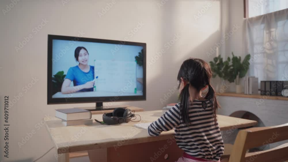 Asian girl student video conference e-learning with female teacher on computer in living room at home. New normal for Online remote distance learning during lockdown Asian girl student video conference e-learning with female teacher on computer in living room at home. New normal for Online remote distance learning during lockdown