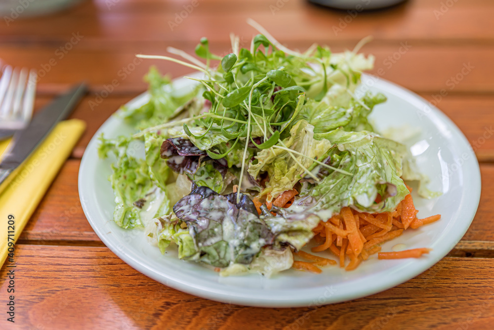 Green vegan salad from green leaves mix and vegetables. Top view on wooden table. Green vegan salad from green leaves mix and vegetables. Top view on wooden table.