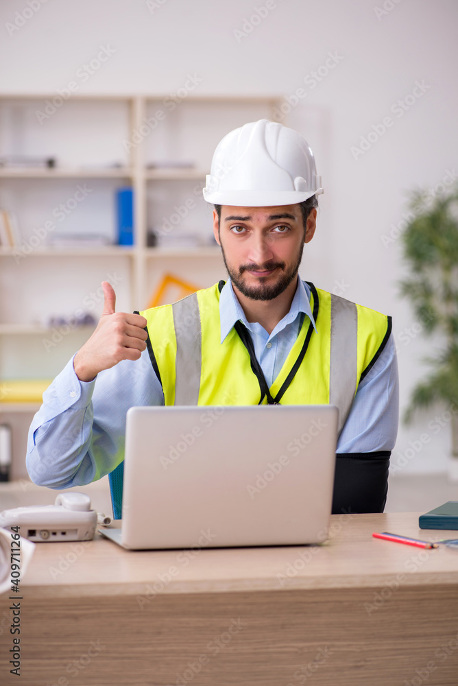 Young arm injured male architect working in the office Young arm injured male architect working in the office