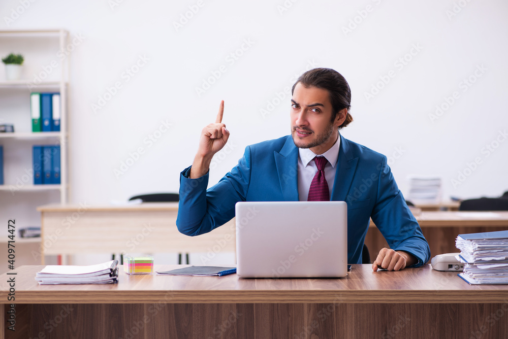 Young male employee working at workplace Young male employee working at workplace