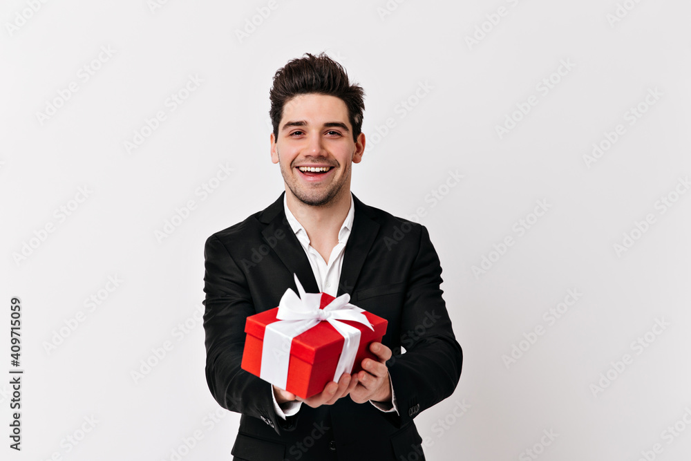 Studio shot of smiling man with birthday gift. Guy in black jacket celebrating valentine's day. Studio shot of smiling man with birthday gift. Guy in black jacket celebrating valentine's day.
