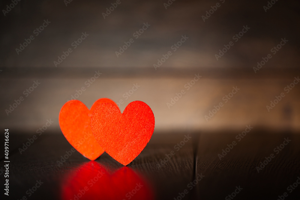 Against the background of a dark tree two red hearts, use as a background or postcard Against the background of a dark tree two red hearts, use as a background or postcard