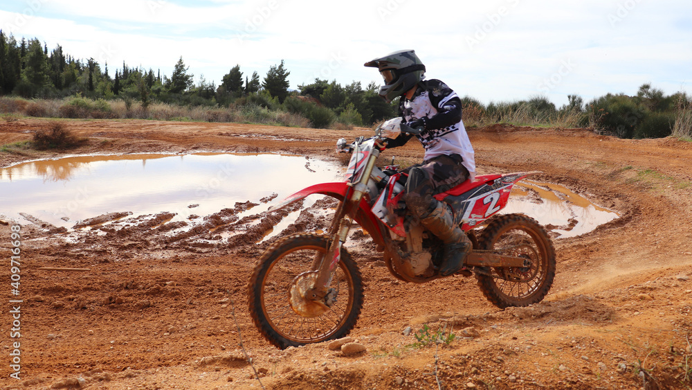 Professional dirt bike motocross rider performing stunts in extreme terrain track Professional dirt bike motocross rider performing stunts in extreme terrain track