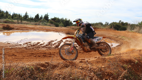 Fototapeta Naklejka Na Ścianę i Meble -  Professional dirt bike motocross rider performing stunts in extreme terrain track