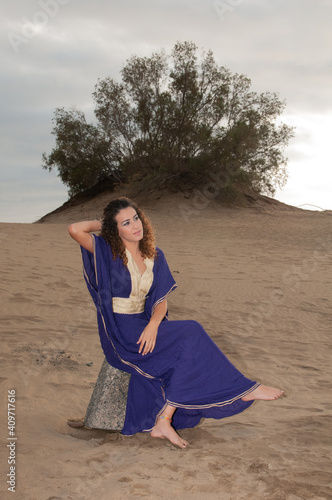 Arab belly dancer in the desert at sunset