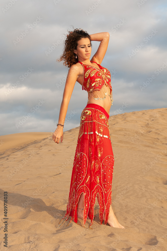 Arab belly dancer in the desert at sunset Arab belly dancer in the desert at sunset