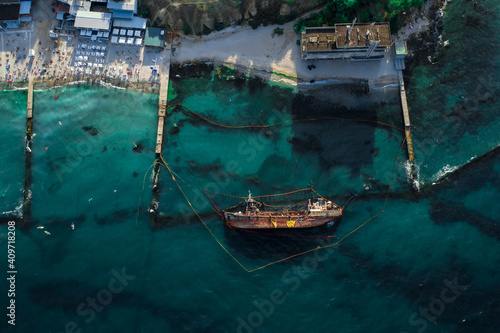 Top view of an old tanker that ran aground and overturned