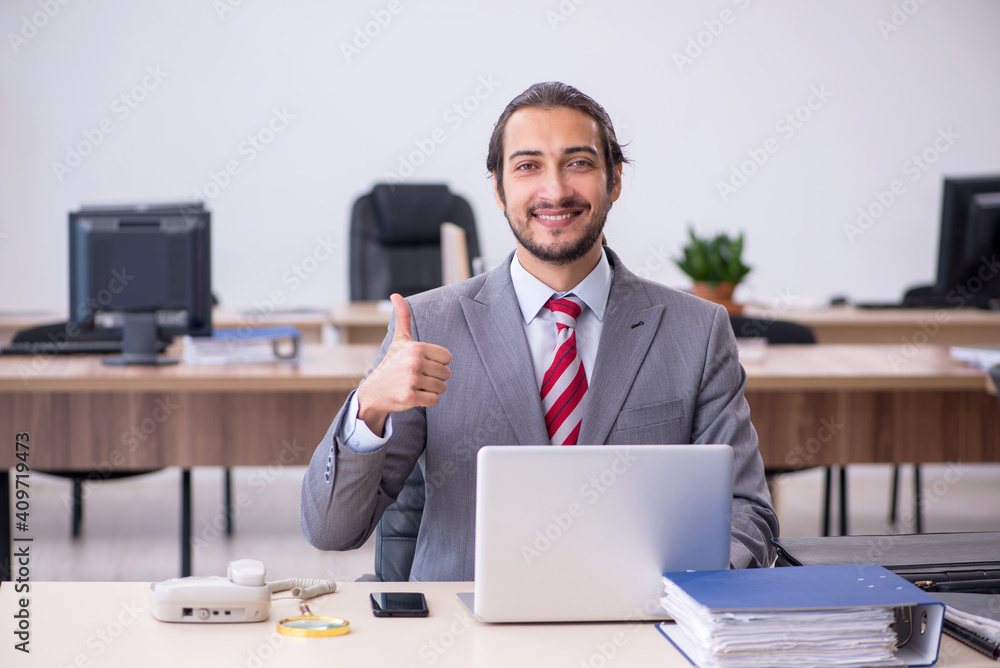 Young male employee working in the office Young male employee working in the office