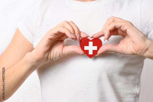 Love Switzerland. The girl holds a heart in the form of the flag of Switzerland on her chest. Swiss patriotism concept