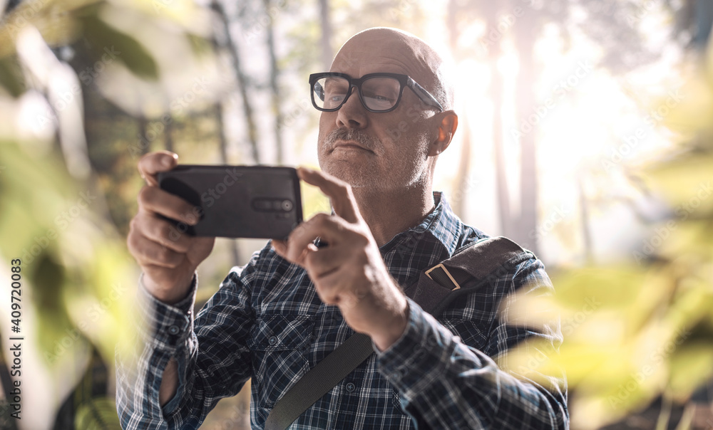 Man taking pictures in the forest Man taking pictures in the forest