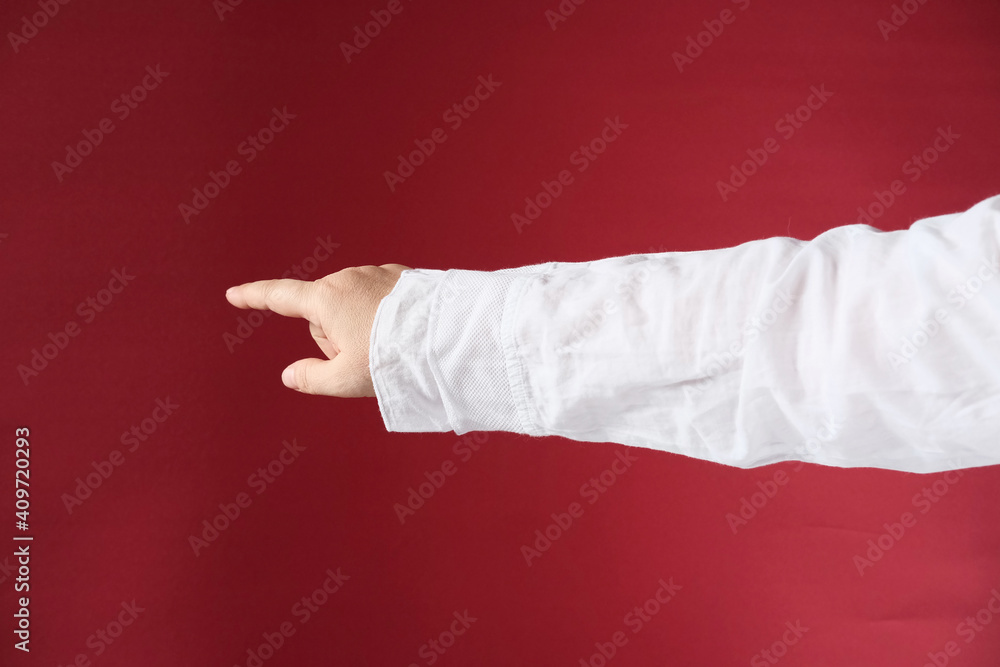 female hand, finger gesture shows direction to the left, red cloth background, space for designer, concept indication, draw attention, arrow